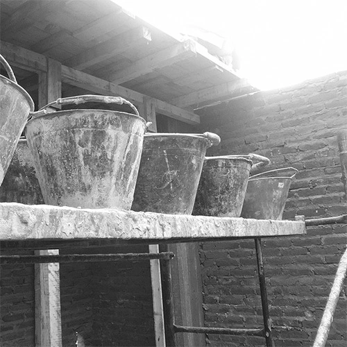 estudio-arquitectura-obras-home imagen de baldes de construcción sobre andamio en blanco y negro, por OUSIA Arquitectos